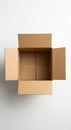 Brown cardboard box with flaps open, placed on a white surface. The corrugated Royalty Free Stock Photo