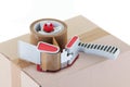 Brown cardboard box and parcel tape dispenser Royalty Free Stock Photo