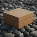 Brown cardboard box on a surface of smooth, gray pebbles. The box is square- Royalty Free Stock Photo
