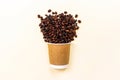Brown cardboard disposable cup with coffee and roasted coffee beans with copy space on light background. Takeaway food concept. Royalty Free Stock Photo