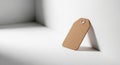 A brown cardboard tag with a hole reinforcement is leaning against a white surface. The tag is Royalty Free Stock Photo