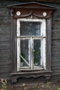 Brown carved platband cracked glass window of old traditional russian wooden house Royalty Free Stock Photo