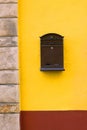 Brown cast-iron mail slot attached on a yellow wall Royalty Free Stock Photo