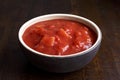 Brown ceramic bowl of chopped tinned tomatoes. Royalty Free Stock Photo