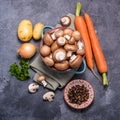 Brown champignons in bowl and vegetables for cooking, ingredients for soup or heatlhy vegan eating, square image