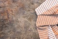 Brown checked towel on a dark vintage background. Top view, flat lay, copy space