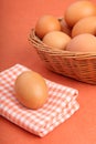 Brown chicken egg on vintage tablecloth and eggs in the basket Royalty Free Stock Photo