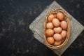 Brown chicken eggs in a basket on a dark rustic background, copy space, top view. Royalty Free Stock Photo