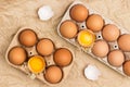 Brown chicken eggs in carton container. Broken egg in container. Eggshell on table Royalty Free Stock Photo