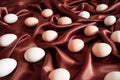 Brown chicken eggs lie on brown silk fabric