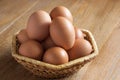 Brown chicken eggs lies in a wicker basket on a wooden table. Th Royalty Free Stock Photo