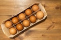 Brown chicken eggs in natural material container. Raw eggs on wooden boards background. Organic farm product concept