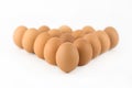 Brown chicken eggs stand in a row in a triangle isolated on white background Royalty Free Stock Photo