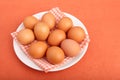 Brown chicken eggs on vintage tablecloth on white plate Royalty Free Stock Photo
