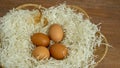 Brown chicken eggs on white paper flake in basket on brown wooden table Royalty Free Stock Photo