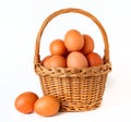 Brown chicken eggs in a wicker basket, isolated on a white Royalty Free Stock Photo