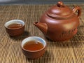 Brown chinese tea set of a teapot and cups on bamboo table mat . Royalty Free Stock Photo