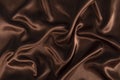 Brown or chocolate silk satin fabric texture background.Cloth soft wave.