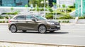 Brown Citroen C4 hatchback is moving on asphalt road in summer day in blurred urban landscape