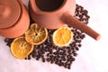 Brown clay dishes, jug with handle for coffee and jug milk, a lot of roasted coffee beans and dried oranges, heart on