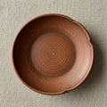 A brown clay plate with a smooth, circular shape and a slightly textured surface, Royalty Free Stock Photo