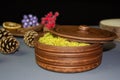 Brown clay pot with yellow moss, covered with a lid. Clay decor on the background of decorative products