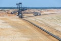 Brown coal open pit landscape with digging excavator in Germany