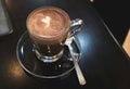 Brown cocoa in coffee cup with white heart shape on black wooden table background Royalty Free Stock Photo