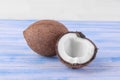 brown coconut and half coconut on a blue wooden table on a white background Royalty Free Stock Photo