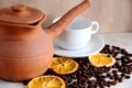 brown coffee Turk pottery, white clean Cup and saucer, roasted coffee beans and dried orange on the table Royalty Free Stock Photo