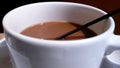 Brown coffee in a white cup with black straw