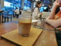 Brown cold mixed espresso shot and white full cream cow milk as flat white in cosy coffee shop Royalty Free Stock Photo