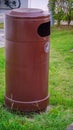 Brown color dust bin placed in a Park at residential area. Royalty Free Stock Photo