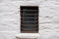 Brown color painted window with security bars on a white wall