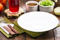 Brown color rustic table mockup, top view, empty round and white plate for food, cutlery on the side, vintage backdrop, homemade
