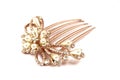 A brown colored hairpin comb with floral design inlaid with artificial pearls and diamonds