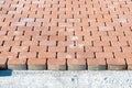 Brown concrete permeable flooring assembled on a substrate of sand. Abstract photo of bricks in the sunlight