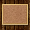 Brown cork board in a frame on wood background. Royalty Free Stock Photo