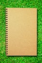 Brown cover notebook on green grass field Royalty Free Stock Photo
