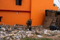 A brown cow standing in heaps of plastic waste and garbage