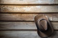 A cowboy hat hangs on grunge wooden wall