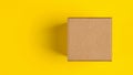 Brown craft paper or carton box with lid mock up on yellow background. Top view of blank small paper box. Brown cardboard box. Royalty Free Stock Photo