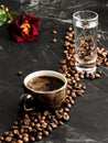 Brown cup with a strong freshly brewed espresso on a black background. Roasted coffee beans are located around the cup. Next to Royalty Free Stock Photo