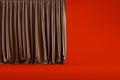 Brown curtain with folds isolated on a red background in the studio Royalty Free Stock Photo