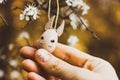 Brown cute funny wooden toy cat, kitten, kitty in a hand, blossoming spring tree Royalty Free Stock Photo