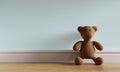 Brown cute teddy bear toy leaning on blue-green pastel background and wooden floor. Kids play and newborn baby room concept. 3D Royalty Free Stock Photo