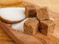 Brown diced cane sugar, refined sugar, white sugar on a wooden plate, sugar consumption concept, easily digestible Royalty Free Stock Photo
