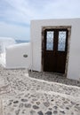 A brown door with a decorative lattice in a white wall on the is