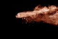 Brown dust explosion cloud.Brown particles splatter on black background Royalty Free Stock Photo