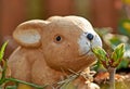 Brown Easter bunny behind a green lilac branch. Royalty Free Stock Photo